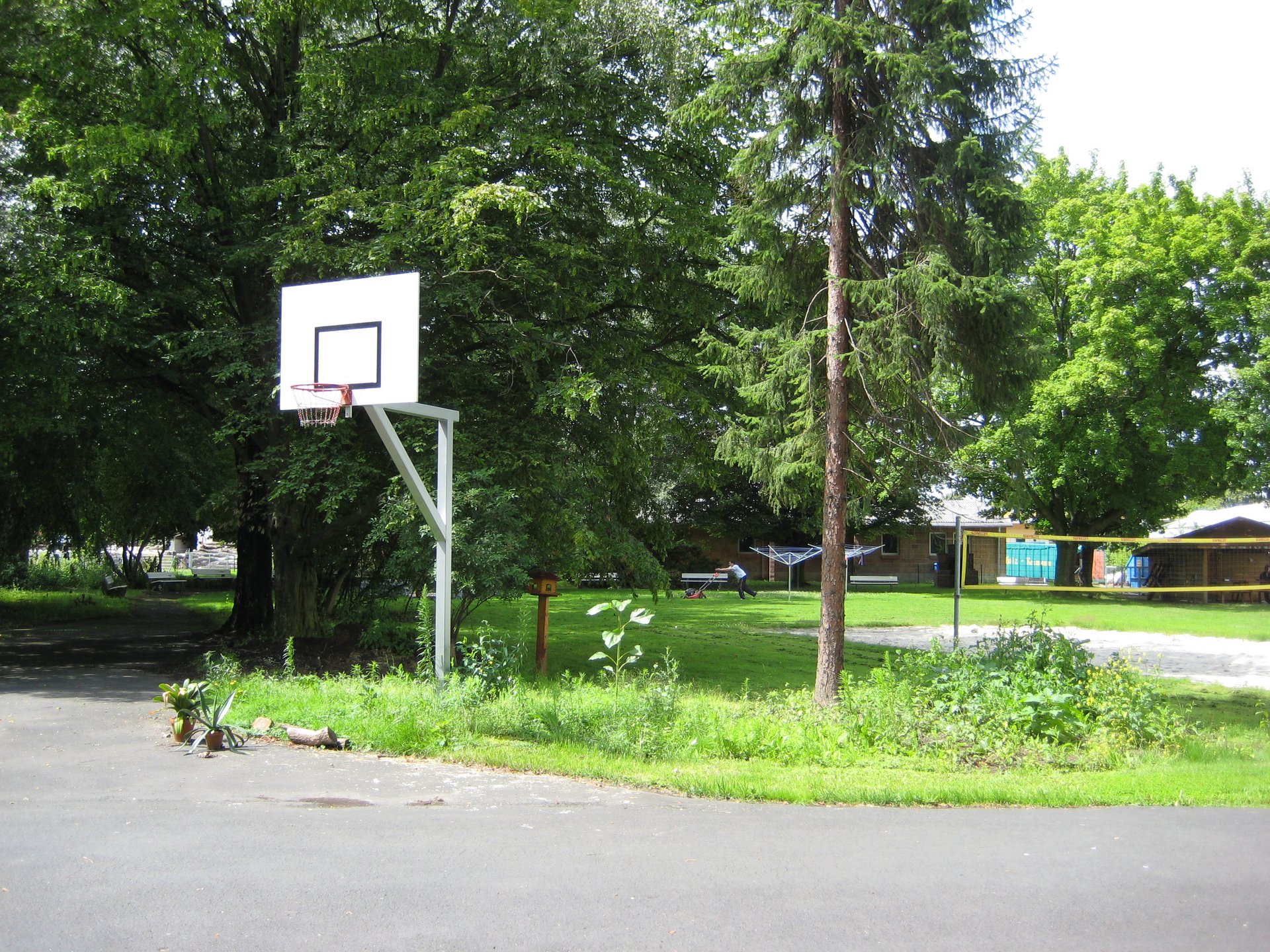 Gartenanlage mit One-On-One-Basketball-Platz und Volleyball-Netz